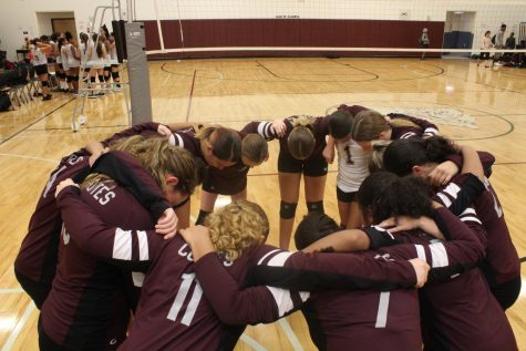 Middle school volleyball team huddled together for a pregame pep talk a few moments before the game against Tapestry begins.