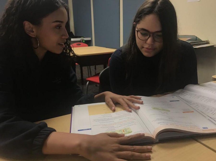 Club members, senior, Kayla Montan, and junior, Tiffany Valentin, reviewing French words