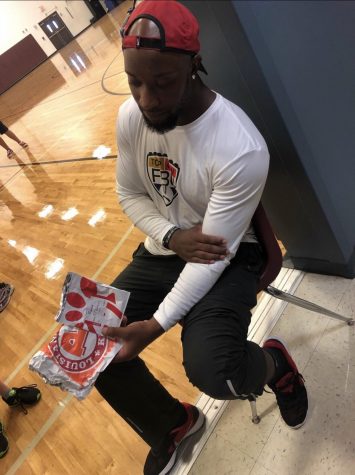 Coach Mike Jones shows off his love of Popeyes and Chick-Fil A sandwiches.