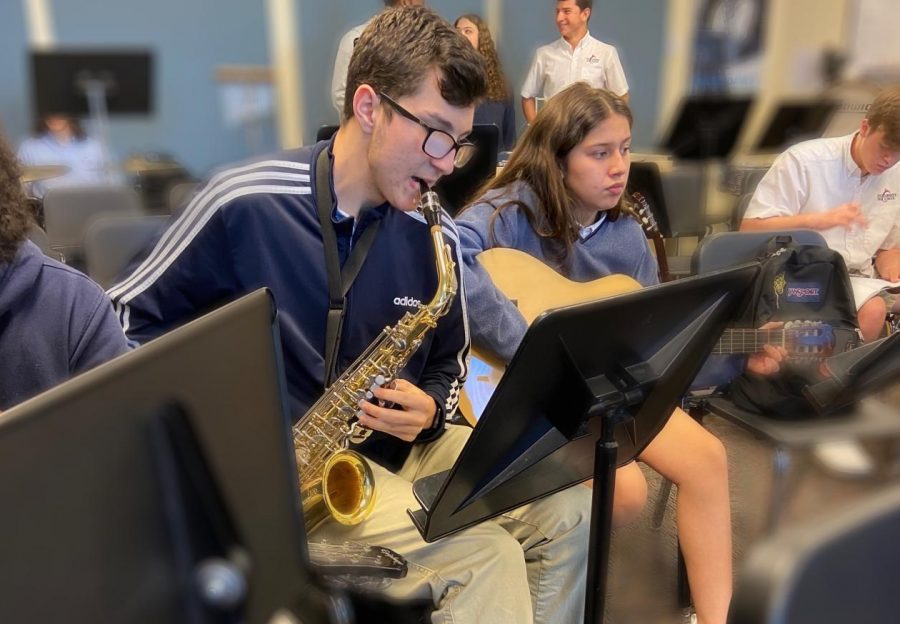 Band member, junior, Ryan Taylor rehearses as a part of the band, which will be performing the school song.