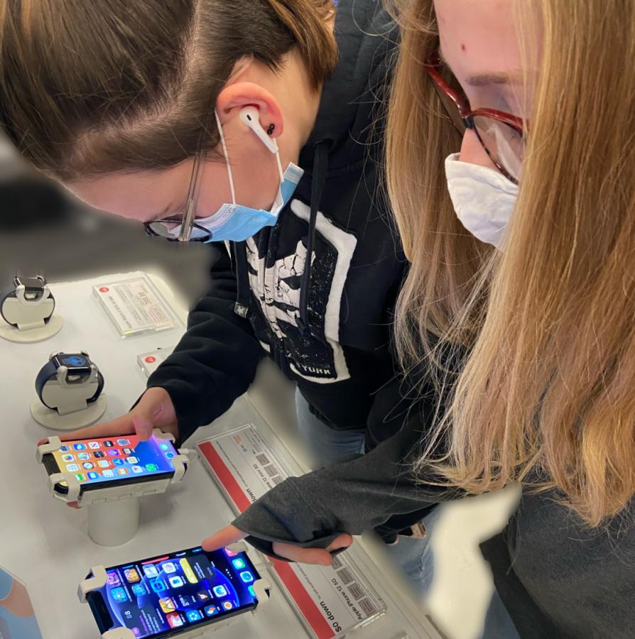 Freshman, Ashlie VanGilder, and seventh grader Meghan VanGilder checking out the new iPhone 12 models.