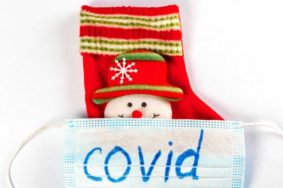 Close-up, mask with the inscription Covid and Christmas sock with snowman by wuestenigel is licensed under CC BY 2.0