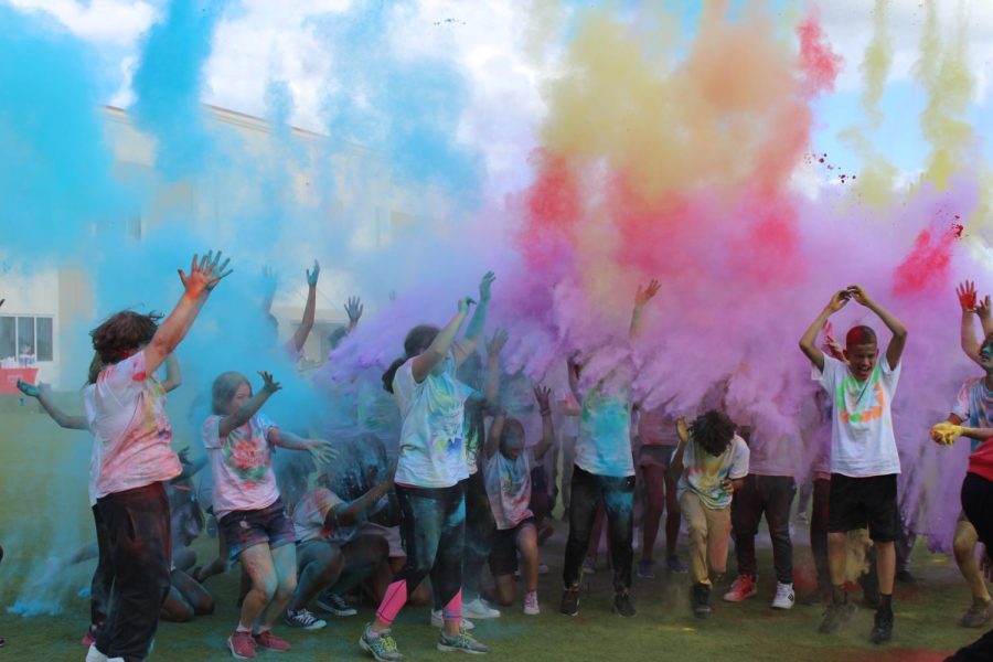 Middle+school+students+in+the+color+run+tossing+colored+powder+in+the+air+after+the+color+run.