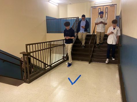 Sophomore David Rivera, Freshman Gabe Sulbaran, Freshamn Rueban Young, and Freshman Matthew Lex follow the blue arrow directing the flow of traffic in the stairway 