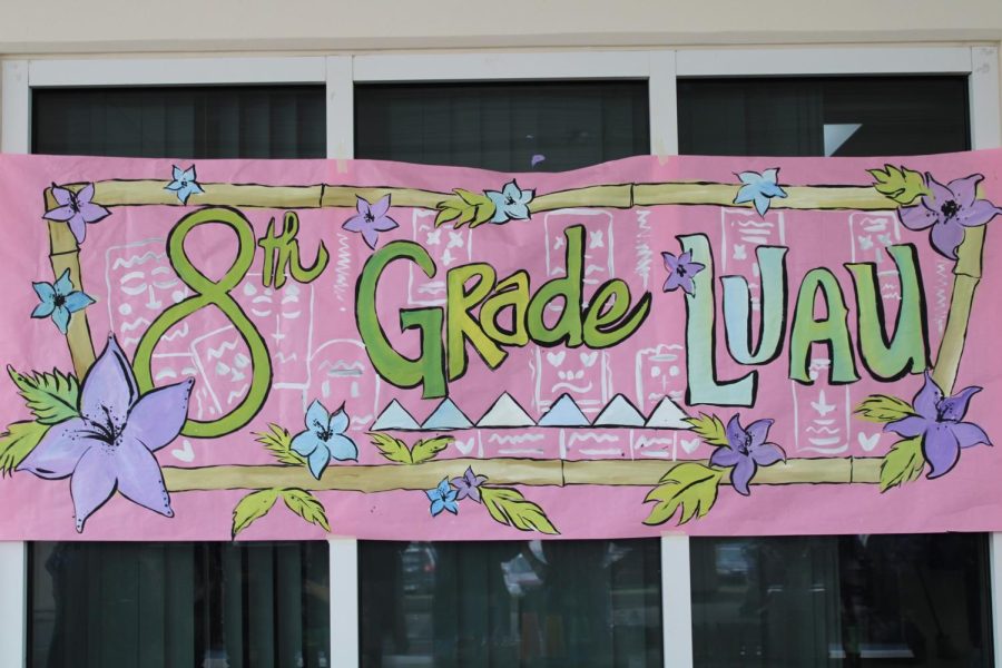 The teachers that set up the luau hung up the banner that says “8th Grade Luau”