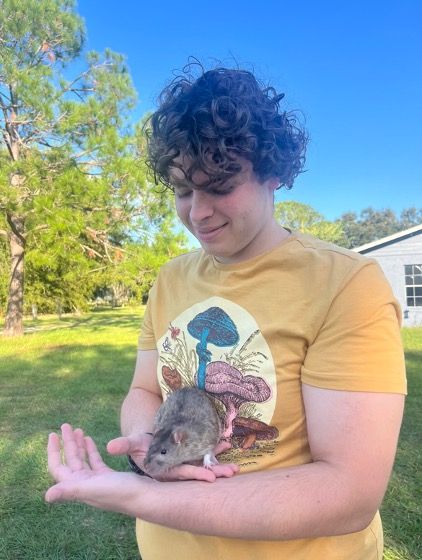Matthew smiles as he holds his pet rat