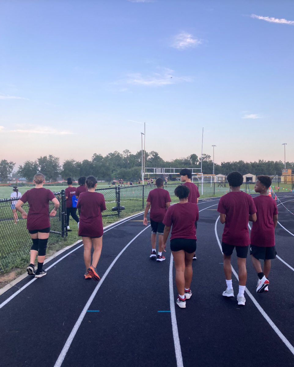 The cross-country team walking on the track to begin warming up.