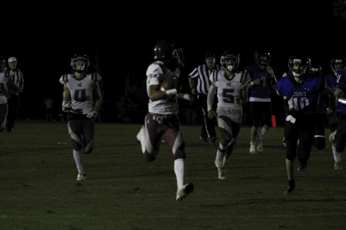 The football team running to make a touchdown. 