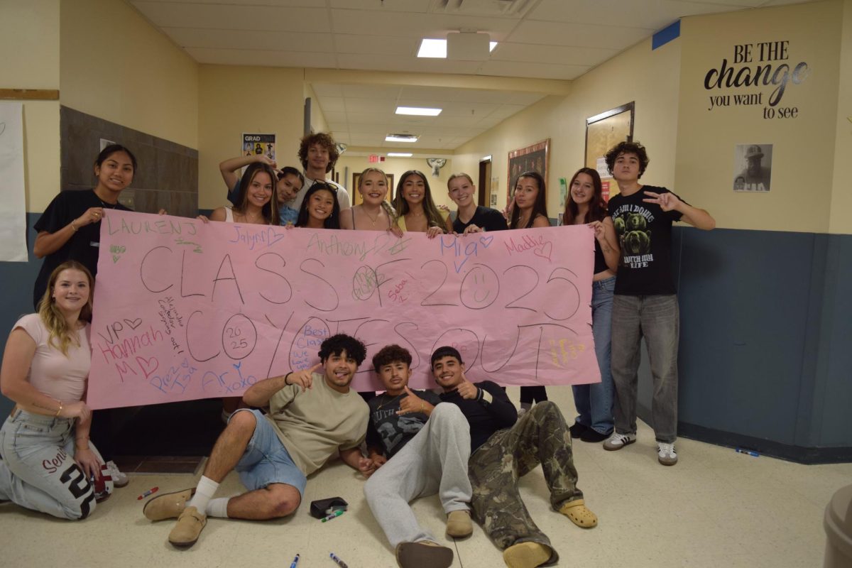 Class of 2025 pose for a photo holding up a senior sign out poster at senior prank. (Courtesy of Isabella Hemenway)
